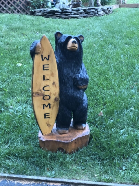 chainsaw carved bear with surfboard