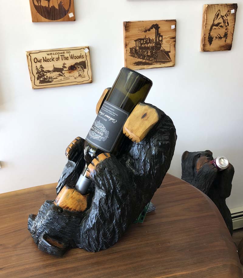 chainsaw carved bear holding wine bottle